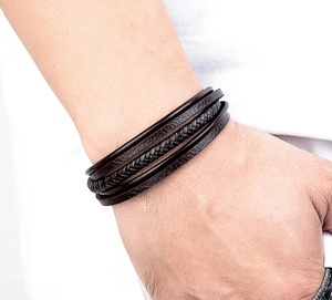 Close-up of a men's layered dark brown braided leather bracelet worn on a wrist