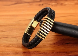 Dettaglio macro del cinturino in pelle intrecciata con fibbia e inserti in metallo dorato