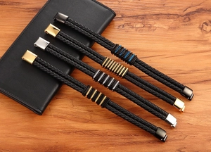 Dettaglio di quattro bracciali da uomo in pelle intrecciata con chiusure in acciaio inossidabile