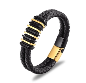 Dettaglio macro del bracciale da uomo in pelle intrecciata con anelli neri e dorati