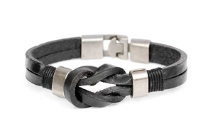 Macro detail of men's braided black leather bracelet with matte metal rings and knot