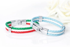 Détail de bracelets en cuir tressé aux couleurs nationales avec fermoir magnétique en acier