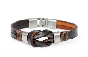 Detail of vintage braided leather bracelet with central knot and metal magnetic clasp
