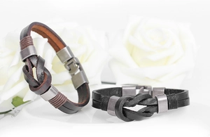 Macro shot of vintage braided leather bracelets in black and brown with metal knot clasps