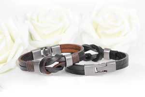 Close-up of braided leather bracelets with vintage knots and metal magnetic clasps