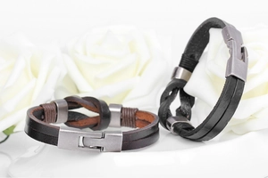 Detail view of woven leather bracelets in brown and black with vintage alloy clasps