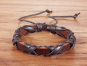 Macro di bracciale in pelle intrecciata marrone scuro con cordino regolabile su legno