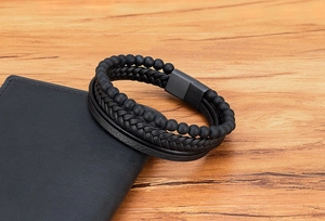 Close-up of men's multi-layer black leather bracelet with matte beads and magnetic clasp