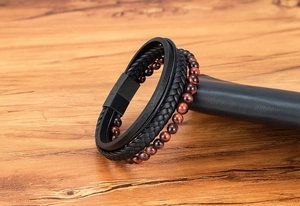 Macro detail of braided black leather with tiger eye stone beads and matte magnetic clasp