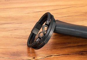 Detail eines mehrlagigen schwarzen Lederarmbands für Herren mit Unendlichkeitssymbol