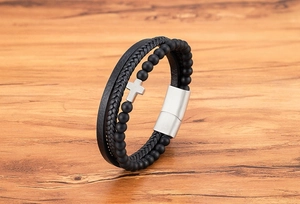 Dettaglio di un bracciale multistrato in pietra naturale con perline nere e croce argento