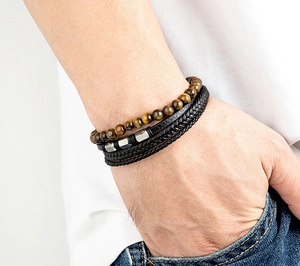 Detail eines mehrlagigen Lederarmbands mit Tigerauge-Perlen und Metallornamenten