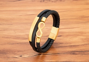 Nahaufnahme eines mehrlagigen schwarzen Lederarmbandes mit goldenem Infinity-Symbol und Magnetverschluss