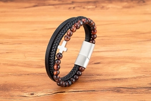 Dettaglio del bracciale multistrato da uomo in pelle con perline occhio di tigre e croce