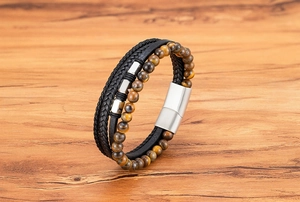 Detail eines mehrlagigen Herren-Lederarmbands mit braunen Tigeraugen-Perlen und Magnetverschluss