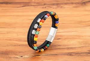 Detailansicht eines mehrlagigen Lederarmbands mit bunten Natursteinen auf Holzfläche