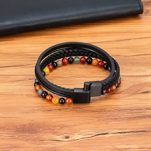 Multilayer men's leather bracelet with colorful natural stones on wooden background
