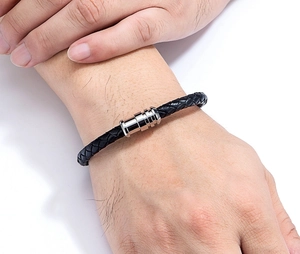Close-up of black braided leather bracelet with silver magnetic clasp on male wrist