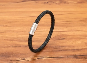 Close-up of black braided leather bracelet with a silver magnetic stainless steel clasp