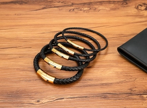 Detailed view of woven black leather bracelets with gold magnetic stainless steel clasps