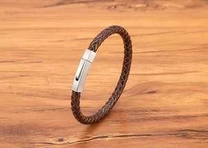 Detailed close-up of dark brown braided leather men's bracelet with silver brushed buckle