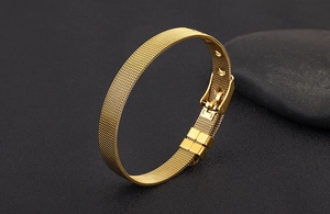 Close-up of golden stainless steel mesh bracelet with adjustable watch band buckle