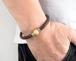 Dettaglio del bracciale in pelle intrecciata a tre colori con chiusura magnetica in acciaio