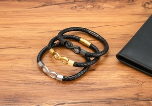 Macro shot of three leather bracelets with infinity symbols in silver, gold, and matte black