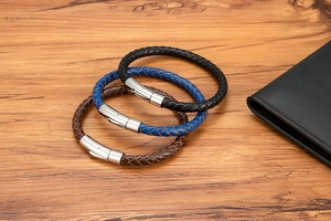 Nahaufnahme geflochtener Lederarmbänder in Schwarz, Blau und Braun mit Magnetschließe