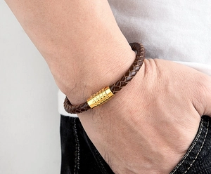 Close-up of brown braided leather bracelet with textured gold magnetic clasp