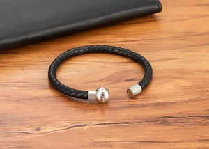 Dettaglio di bracciale in pelle intrecciata nera con chiusura magnetica d'argento