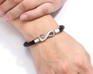 Close-up of infinity symbol on black braided leather bracelet with magnetic clasp