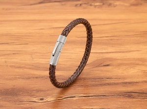 Macro detail van bruine gevlochten leren armband met getextureerde zilveren metalen sluiting