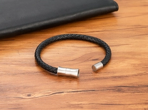 Detail of black braided leather bracelet with brushed stainless steel magnetic clasp