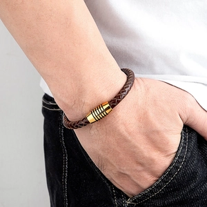 Dettaglio del bracciale in pelle intrecciata marrone con chiusura magnetica dorata