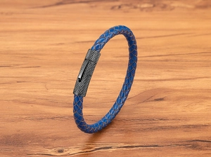 Detailopname van blauwe gevlochten lederen armband met zwarte magnetische sluiting