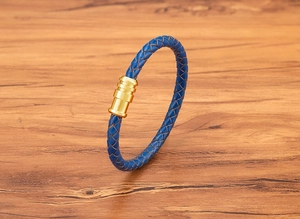 Close-up of blue braided leather bracelet featuring a polished gold magnetic metal clasp