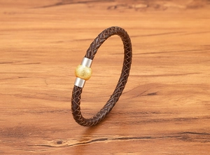 Dettaglio del cinturino in pelle intrecciata da 6mm con perla dorata e chiusura magnetica