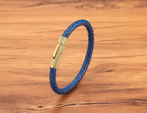 Detailopname van een blauwe gevlochten leren armband met een getextureerde gouden sluiting
