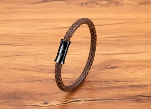 Macro view of dark brown braided leather strap with black magnetic metal clasp