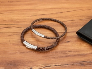 Detaillierte Nahaufnahme brauner geflochtener Lederarmbänder mit silbernem Magnetverschluss für Herren