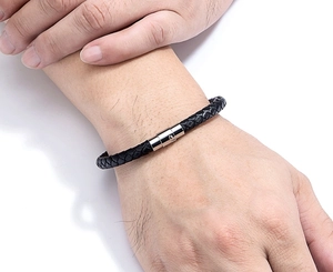 Dettaglio del bracciale in pelle intrecciata nera con chiusura magnetica in acciaio lucido