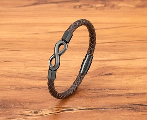 Macro shot of 8-infinity symbol on brown and black braided leather bracelet with magnetic clasp