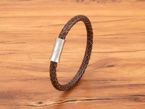 Detail of dark brown braided leather bracelet with a brushed magnetic steel clasp