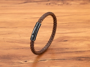 Detail eines dunkelbraun geflochtenen Lederarmbands mit schwarzem Magnetverschluss
