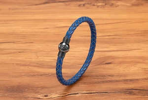 Dettaglio di bracciale in pelle intrecciata blu con chiusura magnetica nera