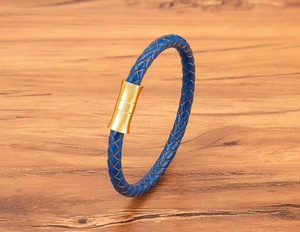 Detail of blue braided leather bracelet with a polished gold magnetic metal clasp
