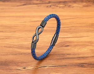 Detail of blue braided leather bracelet featuring black infinity symbol and magnetic clasp