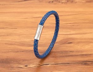 Macro shot of dark blue braided leather bracelet featuring a polished magnetic steel clasp