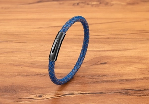 Nahaufnahme von blauem Lederarmband mit schwarzem Metallverschluss auf Holzuntergrund